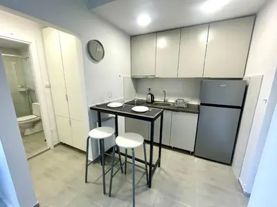 a kitchen with a table and two stools and a refrigerator at Apartment LUX 15 Historical Center Belgrade in Belgrade
