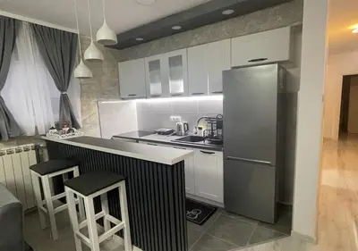 a kitchen with white cabinets and a stainless steel refrigerator at Apartman Manda 2 in Belgrade