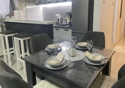 a dining table with plates and wine glasses on it at Apartman Manda 2 in Belgrade