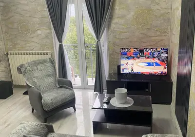a living room with a television and a chair at Apartman Manda 2 in Belgrade