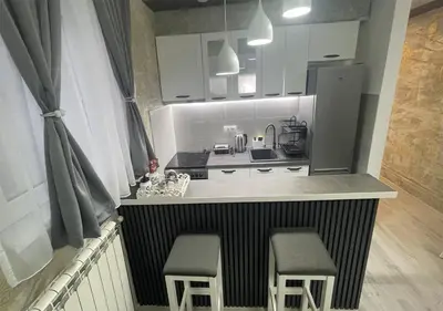 a small kitchen with two stools and a counter with a stove at Apartman Manda 2 in Belgrade