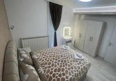 a bedroom with a bed and a couch and a mirror at Apartman Manda 2 in Belgrade