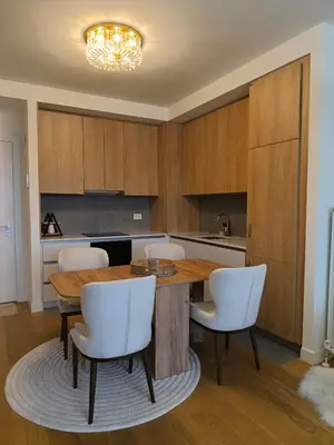 a kitchen with a wooden table and white chairs at Belgrade Waterfront Dream in Belgrade