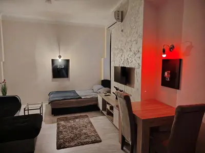 a living room with a bed and a desk with a table at Pablo MovieSTAR in Belgrade