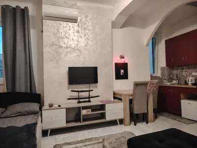 a living room with a table and a tv on a wall at Pablo MovieSTAR in Belgrade