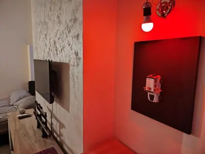 a room with a tv and a red wall at Pablo MovieSTAR in Belgrade