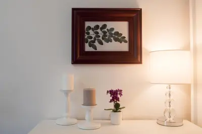 a table with two candles and a picture on the wall at Benvenuti MOON in Belgrade