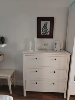 a white dresser with two candles on top of it at Benvenuti MOON in Belgrade