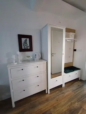 a bedroom with a white dresser and a mirror at Benvenuti MOON in Belgrade