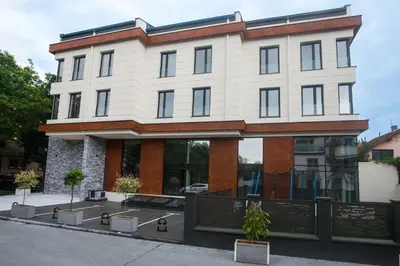 a large white building with windows on a street at Benvenuti MOON in Belgrade