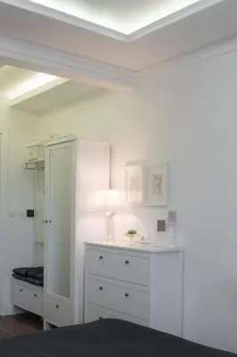 a white room with a dresser and a lamp at Benvenuti MOON in Belgrade
