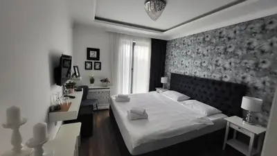 a bedroom with a large white bed and a desk at Benvenuti STAR in Belgrade