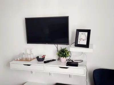 a white entertainment center with a flat screen tv on a wall at Benvenuti STAR in Belgrade