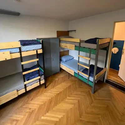 a room with three bunk beds and a wooden floor at Chillton hostel in Belgrade