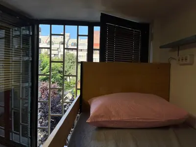 a bedroom with a bed and a large window at Chillton hostel in Belgrade