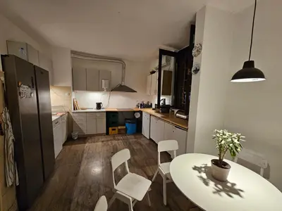 a kitchen with a white table and chairs and a table and a dining room at Chillton hostel in Belgrade