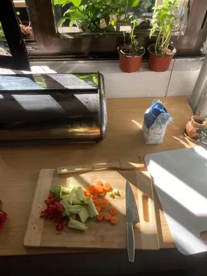 a cutting board with vegetables and a knife on a table at Chillton hostel in Belgrade