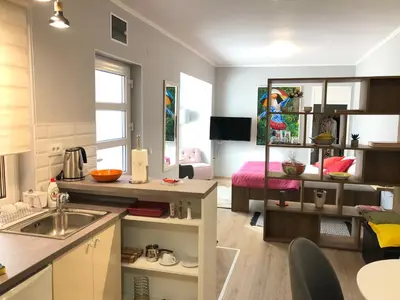 a kitchen with a sink and a living room at ZeMoon Apartment in Belgrade