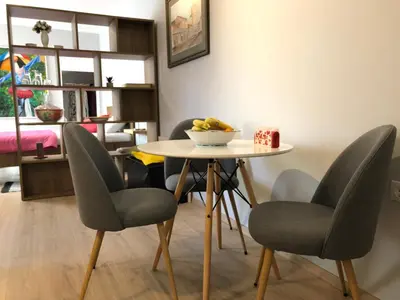 a table with chairs and a bowl of fruit on it at ZeMoon Apartment in Belgrade