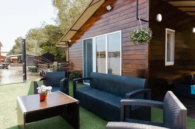 a patio with a couch and chairs and a table at Splav na Savi - House on the river in Ostrvo Sprud