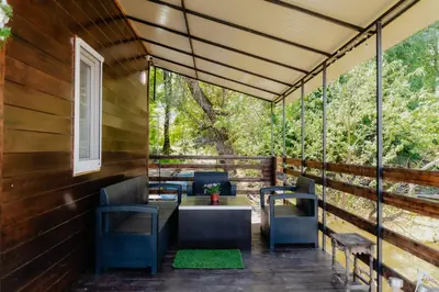 a deck with chairs and a table and a window at Splav na Savi - House on the river in Ostrvo Sprud