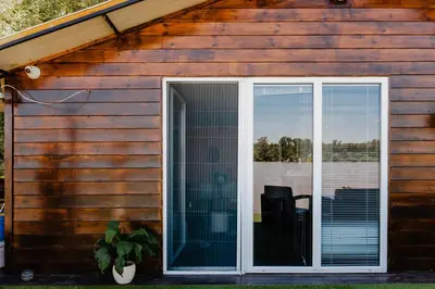 a sliding glass door of a house with a window at Splav na Savi - House on the river in Ostrvo Sprud
