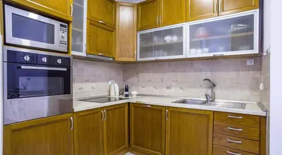 a kitchen with wooden cabinets and a sink and a microwave at Apartment in city center of Belgrade in Belgrade