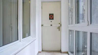 a white door with a sign on it next to windows at Apartment in city center of Belgrade in Belgrade