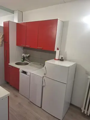 a kitchen with white appliances and red cabinets at Stan na dan Banovo brdo in Belgrade