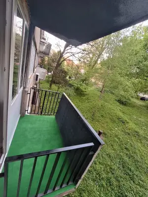 a balcony with a green floor on a house at Stan na dan Banovo brdo in Belgrade