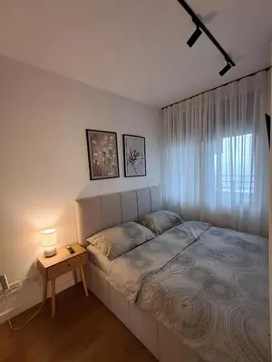 a bedroom with a bed and a table with a lamp at New Luxury Suite with Garrage in Belgrade