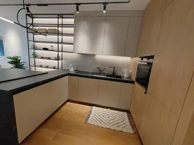 a kitchen with white cabinets and a black counter top at New Luxury Suite with Garrage in Belgrade