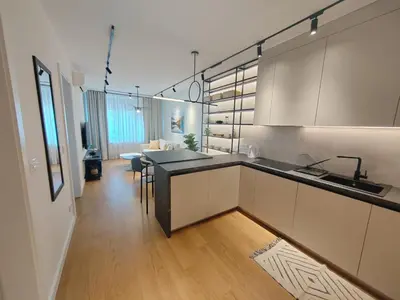 a kitchen with white cabinets and a dining room at New Luxury Suite with Garrage in Belgrade