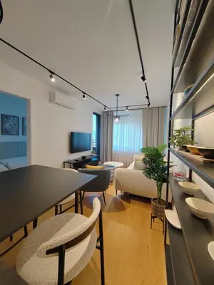 a living room with a table and chairs and a couch at New Luxury Suite with Garrage in Belgrade