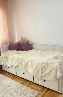 a white bed with purple pillows in a bedroom at Cozy Work-Friendly flat with Backyard near forest in Belgrade