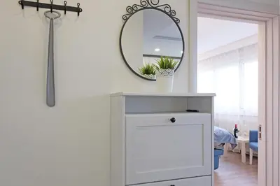a mirror above a white dresser in a room at New Belgrade Roses Apartment in Belgrade