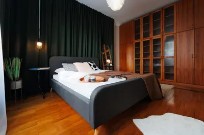 a bedroom with a large bed with green curtains at Colored Happiness 115m2 with Balcony Old Town in Belgrade