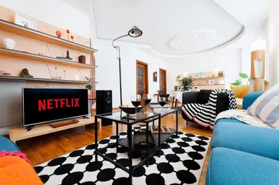 a living room with a tv and a blue couch at Colored Happiness 115m2 with Balcony Old Town in Belgrade