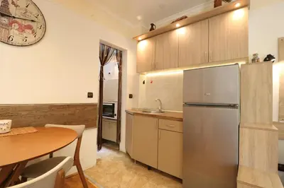a kitchen with a table and a stainless steel refrigerator at Studio Apartman Vladar in Belgrade