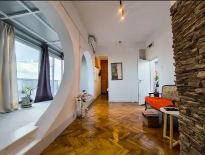 a large living room with a stone wall at on top of the city in Belgrade