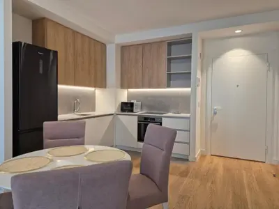 a kitchen with a table and chairs in a room at Q4, flat near Gallery shopping mall with garage in Belgrade