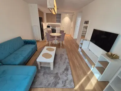 a living room with a blue couch and a table at Q4, flat near Gallery shopping mall with garage in Belgrade