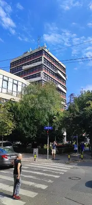 a man standing in a crosswalk in front of a building at The Best Offer in Belgrade