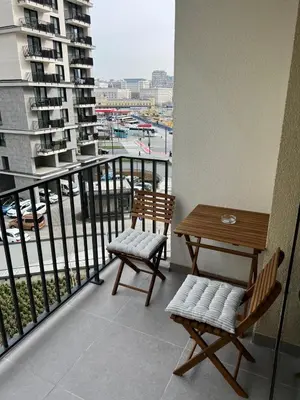 a balcony with two chairs and a table on a building at BW Simfonia Apartman 407-whit free garage parking in Belgrade