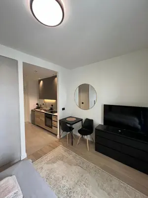 a bedroom with a bed and a table and a mirror at BW Simfonia Apartman 407-whit free garage parking in Belgrade