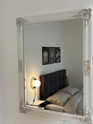 a mirror reflecting a bed in a room at Sleep&Fly 1 Belgrade in Belgrade