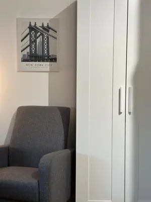 a room with a chair and a white cabinet at Sleep&Fly 1 Belgrade in Belgrade