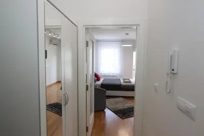 a room with a mirror and a bedroom with a bed at Apartment Moonstone 3 in Bežanija