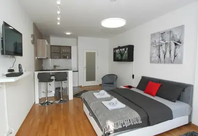 a bedroom with a large bed and a kitchen at Apartment Moonstone 3 in Bežanija