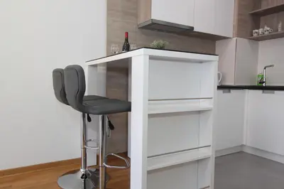 a bar in a kitchen with a black chair at Apartment Moonstone 3 in Bežanija